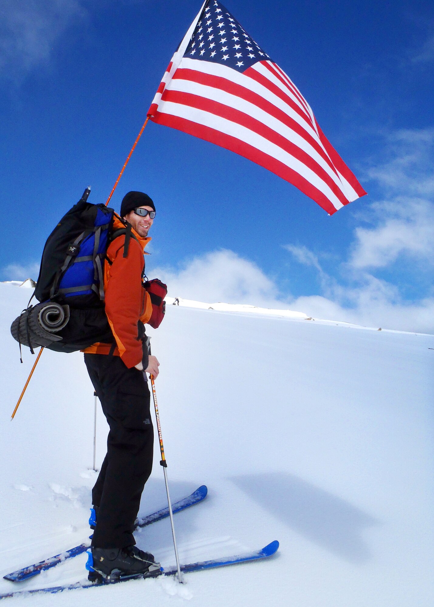 Capt. Graydon Muller, pilot with the 6th Special Operations Squadron, Hurlburt Field, Fla., skis down from the summit of Australia?s highest mountain, Mount Kosciuszko, with the American flag flying overhead, Oct. 3, 2011.  This was part of the U.S. Air Force 7 Summits Challenge, where a group of Airmen have made the goal of climbing to the top of each continent?s highest mountain.  (Courtesy photograph)
