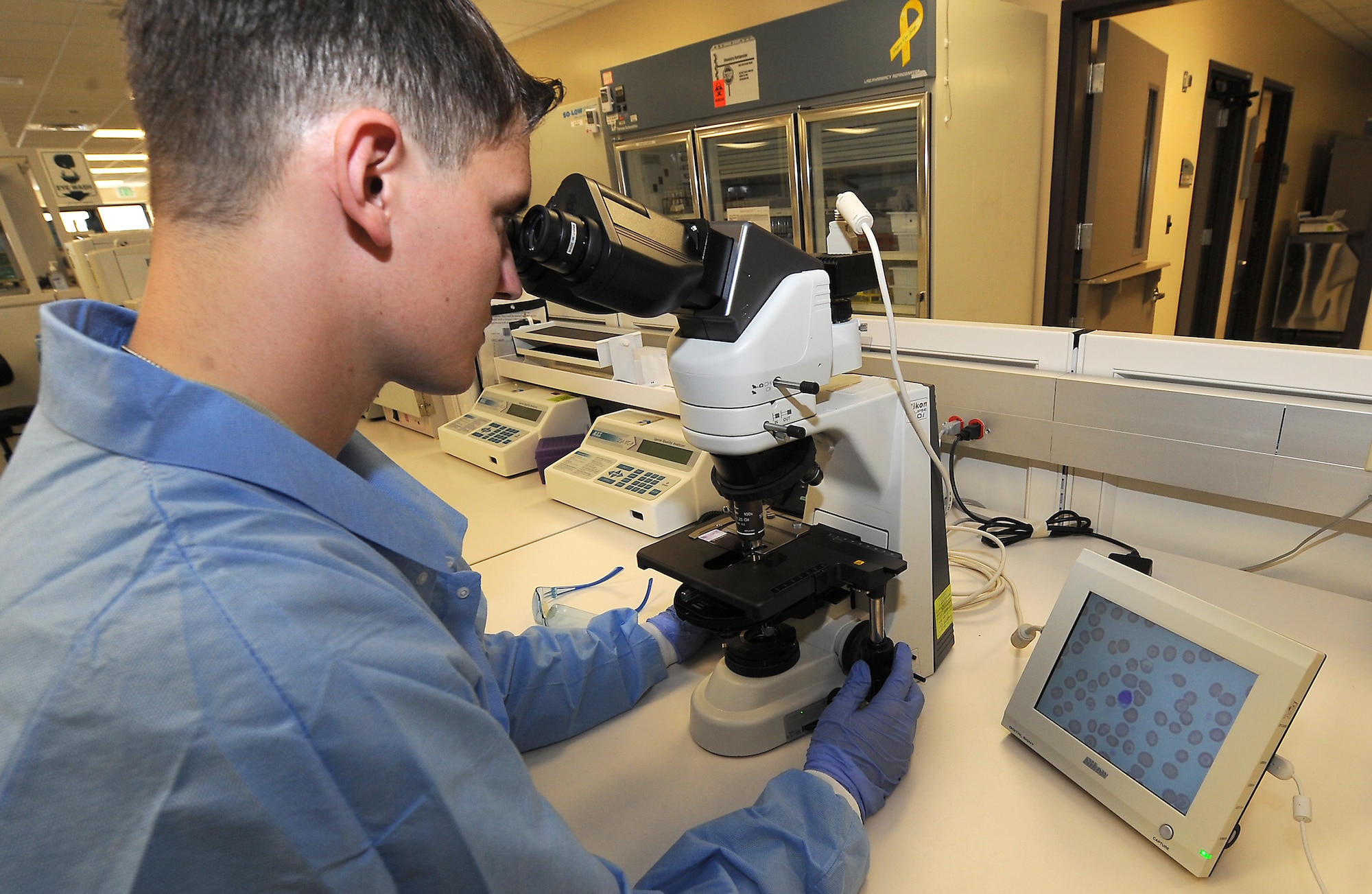 Airman 1st Class Timothy Rybinski, lab technician, manually reviews white blood cells for abnormalities Oct. 14 on the new state of the art microscopes at the David Grant USAF Medical Center laboratory. (U.S. Air Force photo/ Staff Sgt. Liliana Moreno)