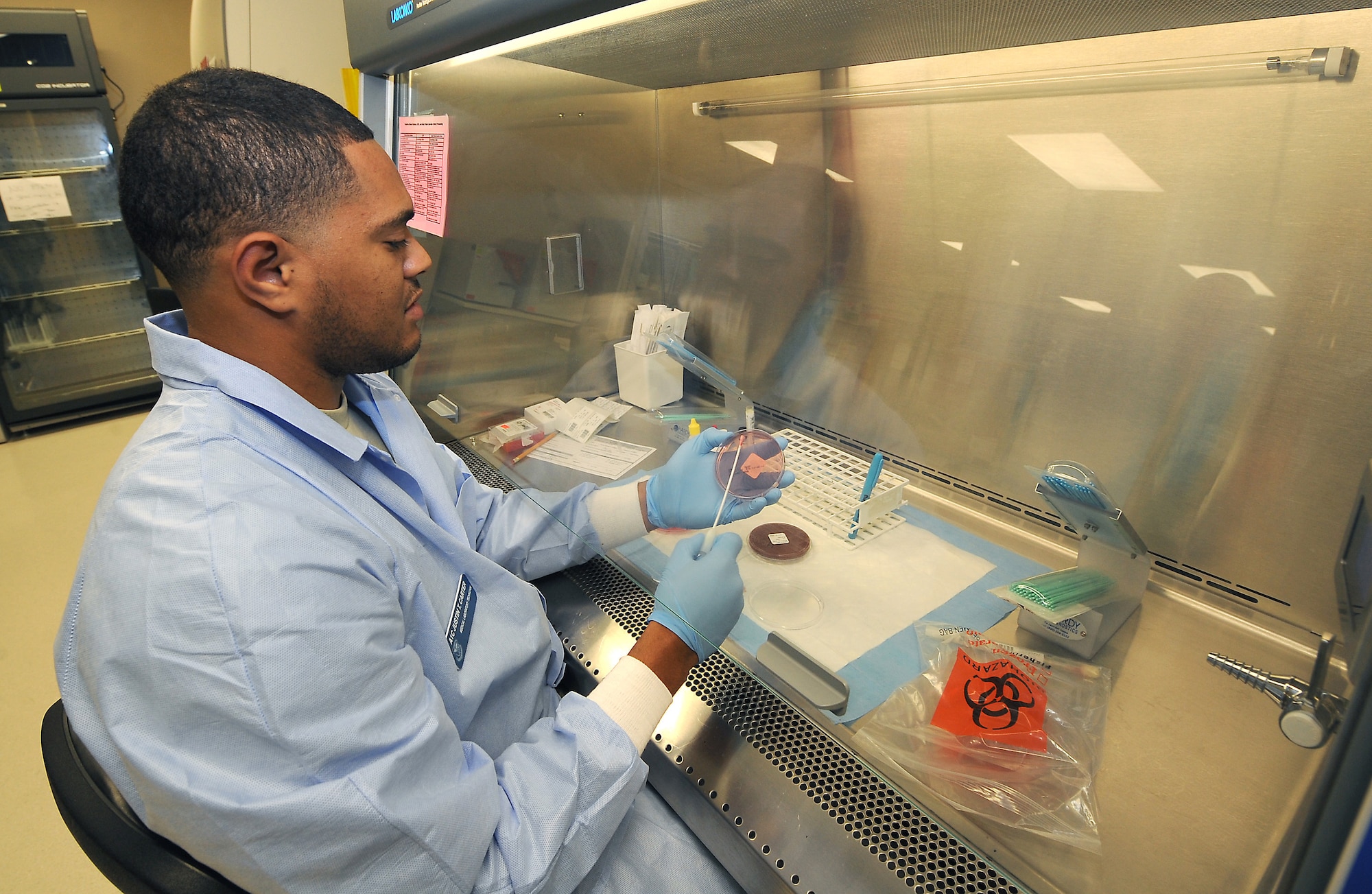 Airman 1st Class Justin Carter, lab technician, plates a specimen for a bacteria culture Oct. 14 at the David Grant USAF Medical Center laboratory. (U.S. Air Force photo/ Staff Sgt. Liliana Moreno)