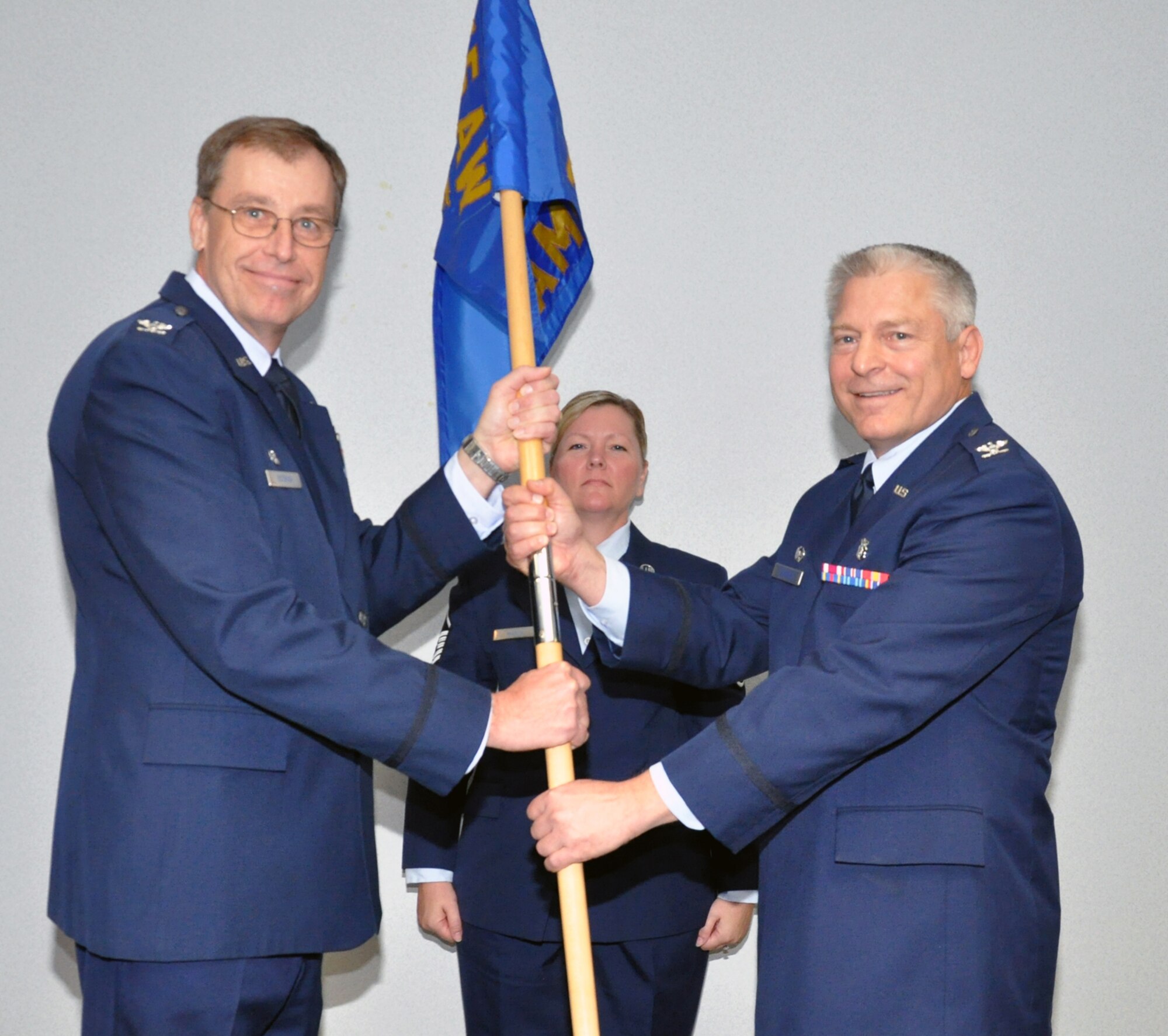WRIGHT-PATTERSON AIR FORCE BASE, Ohio – Col. Stephen Goeman, 445th Airlift Wing commander, passes the guidon to Col. Scott Sayre, incoming 445th Aerospace Medicine Squadron, during the Oct. 2 Assumption of Command ceremony. Sayre was assigned to the 445th AMDS as the chief dental officer prior to his new position. (U.S. Air Force photo/Senior Airman Matthew Cook)