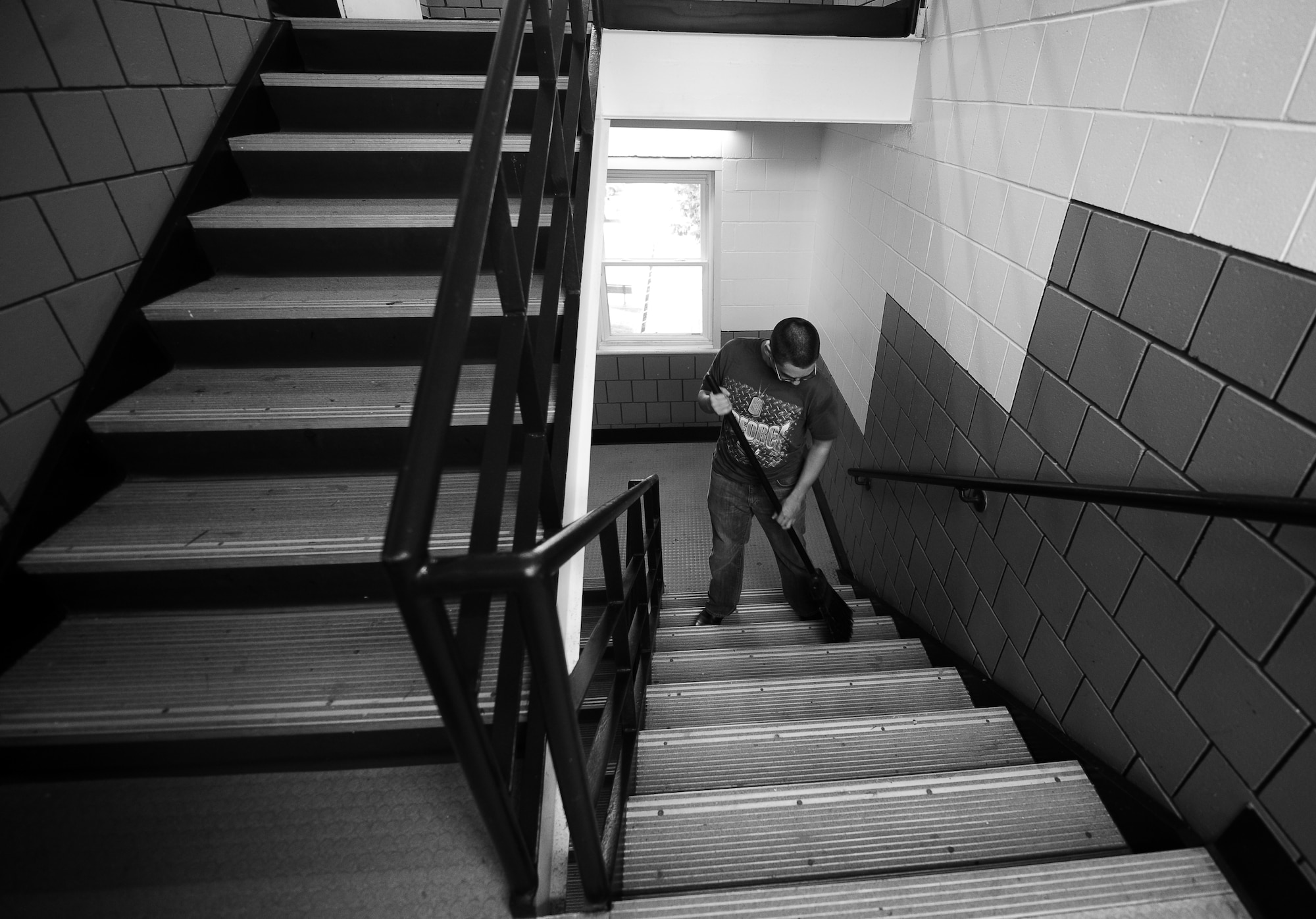 U.S. Air Force Airman 1st Class Stephen Switzer, 55th Strategic Communications Squadron, sweeps a stairwell inside Turner Hall as part of the dorm clean-up at Offutt Air Force Base, Neb., Sept. 24.  Airman paid close attention to detail as they cleaned and updated common areas in the four base dorms.  (U.S. Air Force photo by Josh Plueger/Released)