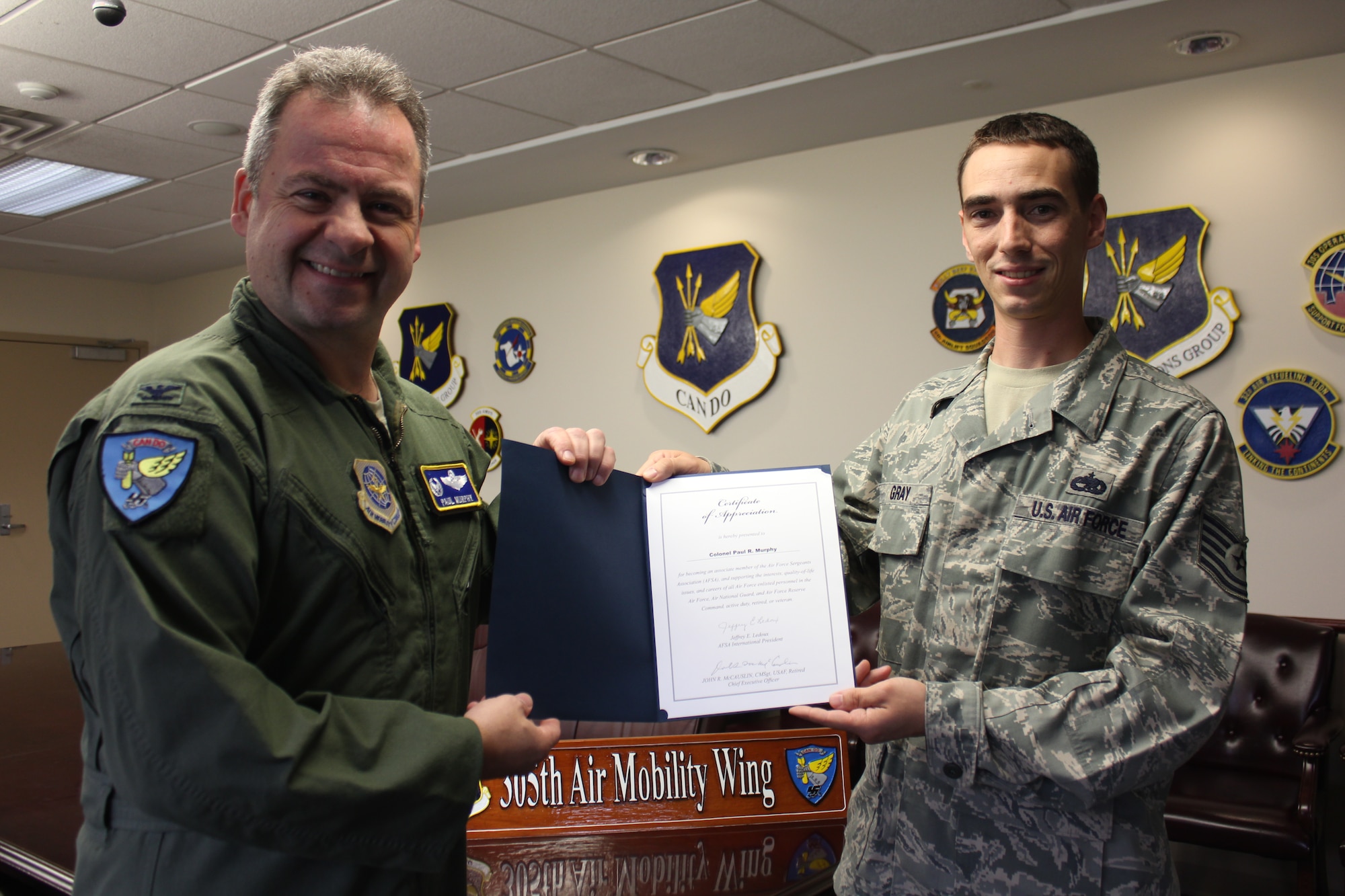 Col. Paul Murphy, 305th Air Mobility Wing commander, receives an Air Force Sergeant Association honorary membership certificate for his tremendous support for the organization from Tech. Sgt. Conor Gray, 373rd Training Squadron and AFSA representative, Oct. 14 here. AFSA is the Air Force enlisted organization dedicated solely to the people behind the stripes. AFSA has led the way on both Capitol Hill, in the Pentagon and in the White House. (U.S. Air Force photos by Tech. Sgt. Francis Lalic/Released)