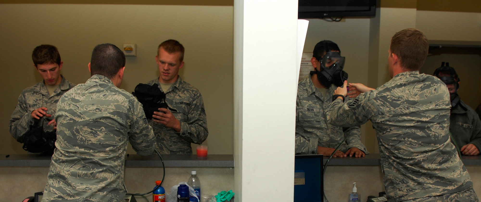 U.S. Air Force Senior Airman Ryan Smith and Staff Sgt. Bryan Stewart, 20th Civil Engineer Squadron readiness apprentices, assist Airmen for the M50 gas mask testing for the initial fit, Shaw Air Force Base, S.C. Oct. 20, 2011. The M50 mask replaced the MCU-2/P gas mask to improve breathing resistance and field of view. (U.S. Air Force photo by Airman 1st Class Ashley L. Gardner/ Released)