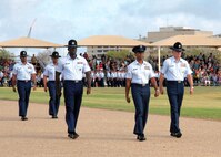 Tech. Sgt. Gabriel Lewis and Senior Master Sgt. Marc Schoellkopf, members of the 737th Training Group, flank retiring 37th Training Wing Command Chief Master Sgt. Jay Simon as he marches down the bomb run during Air Force basic training graduation ceremony Oct. 7. (U.S. Air Force photo/Alan Boedeker)
