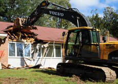 An empty home is demolished at Joint Base Charleston - Air Base Oct. 20, in order to make room for the new privatized housing which will be constructed by Forest City Military Communities. The privatization project will involve the demolition of 468 existing housing units and construction of 335 new homes. The new homes are scheduled to begin to become available in the fall of 2012. (U.S. Air Force photo/Staff Sgt. Katie Gieratz)