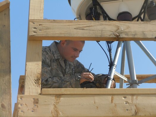 Airman 1st Class Michael Becker of the Weather Systems Support Cadre - Operation Enduring Freedom secures radome cable harnesses to the platform for a Portable Doppler Radar system in Southwest Asia recently. The Electronic Systems Center has fielded a fifth PDR system to the area of responsibility for initial operational evaluations. (Courtesy photo)