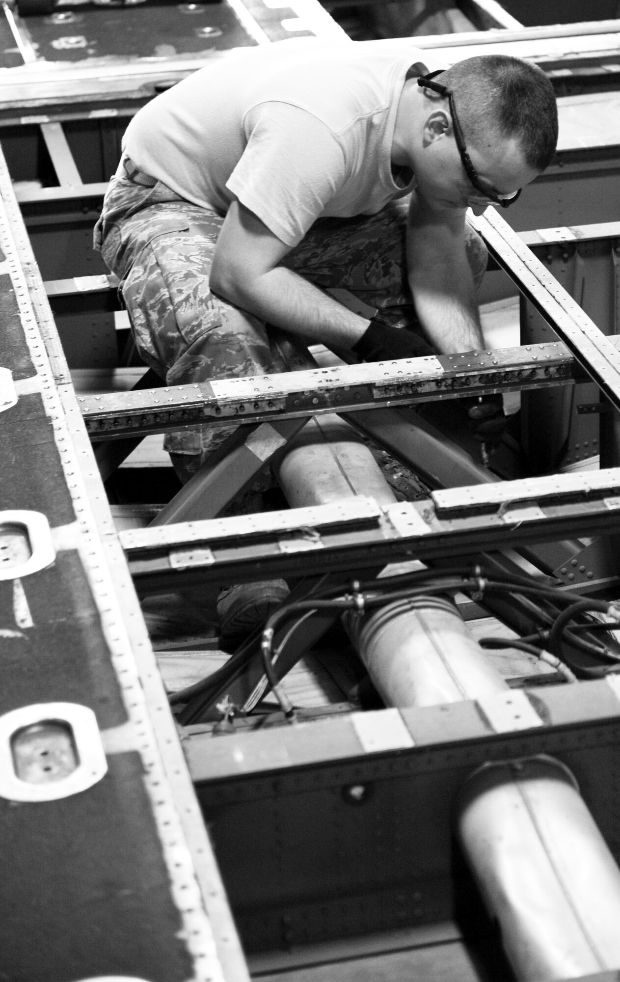 YOKOTA AIR BASE, Japan -- Senior Airman Timothy Butler, 374th Maintenance Squadron fabrication flight aircraft structural maintainer, installs high locks on a C-130 Hercules bulkhead at Yokota Air Base, Japan, Oct. 19, 2011. Butler, along with six other structural maintainers, removed and repaired four bulkheads for an inspection. (U.S. Air Force photo/Airman 1st Class Krystal M. Garrett)  