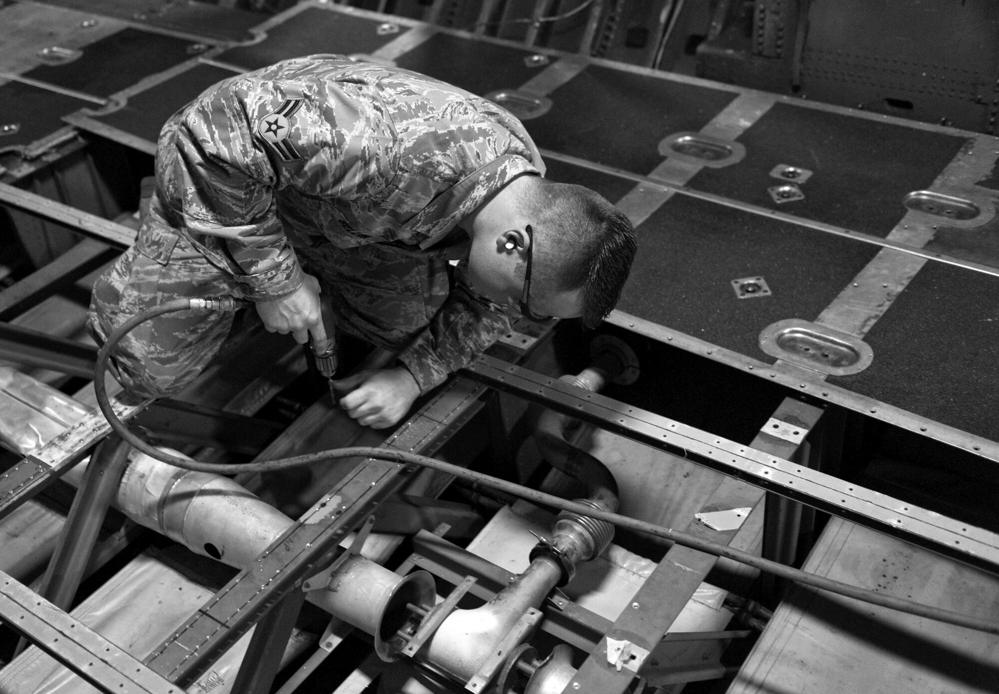 YOKOTA AIR BASE, Japan -- Airman 1st Class Jeffrey Sellon, 374th Maintenance Squadron fabrication flight aircraft structural maintainer, checks for proper alignment while installing repaired parts on a C-130 Hercules bulkhead at Yokota Air Base, Japan, Oct. 19, 2011. The aircraft structural maintainers removed damaged parts, fabricated new ones and installed them. (U.S. Air Force photo/Airman 1st Class Krystal M. Garrett) 
