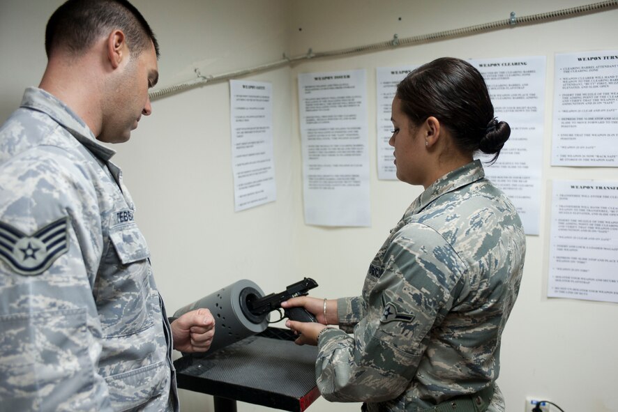 Staff Sgt. Eric Tebbano, 39th Air Base Wing command post, watches for proper clearing procedures as Airman Jordan Rodgers, 39th ABW CP, clears a weapon before turning it in, Oct. 11, 2011, at Incirlik Air Base, Turkey. The command post is responsible for relaying emergency messages across the base and to commanders, along with getting emergency responders to emergencies quickly. (U.S. Air Force photo by Senior Airman Clayton Lenhardt/Released)