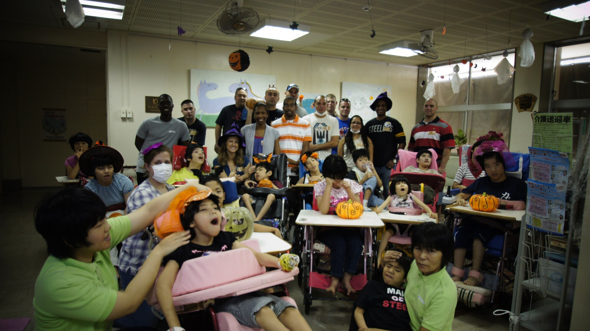 Students from Kadena Air Base NCO Academy Class 11-7 Falcon Flight, pose for a photo with members of the Okinawa Children’s Development Center in Okinawa City, Japan, Oct. 15. The students decorated the facility with Halloween items, as well as made decoration items with the special-needs children. (U.S. Air Force photo/Keiko Toma/released)