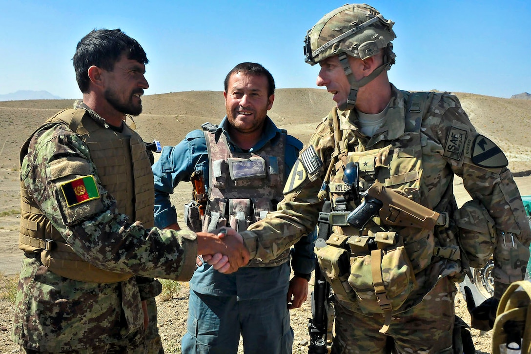 Afghan National Army Maj. Abdul Gafar, left, shakes hands with U.S. Army Brig. Gen. Gary Volesky, right, while a member of the Afghan police looks on during Operation Shamshir in the Mata Khan district, Paktika province, Afghanistan, Oct. 19, 2011. Volesky is deputy commanding general of the 1st Cavalry Division.