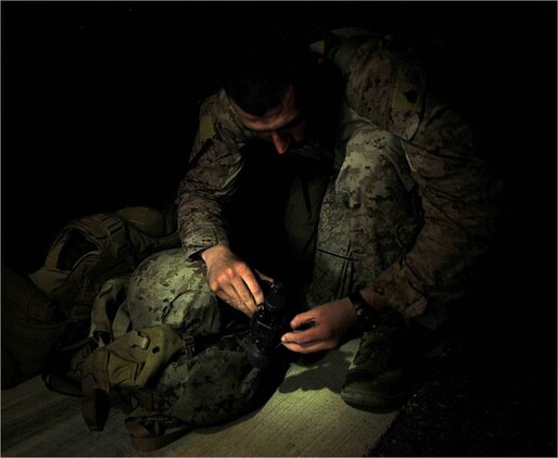 U.S. Marine Sergeant Christopher Bickel, Marine Air Traffic Control Mobile Team assistant team leader, 22nd Marine Expeditionary Unit, prepares his night vision goggles before checking the alignment of phantom lights on an austere landing zone at Chabelley Airfield, Djibouti, October 21. Bickel is originally from Lima, Ohio. He is part of a team that sets up ALZs, which allow aircraft such as C-130 Hercules and C-17 Globemaster III cargo transport aircraft to land anywhere in the world, day or night.