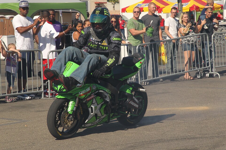 Jason Britton, a stunt rider for No Limit Entertainment, rides on the handle bars of his Kawasaki during the third annual Commanding General’s Car and Bike Show at the 5th Street and Brown Street parking lot Oct. 22, 2011.