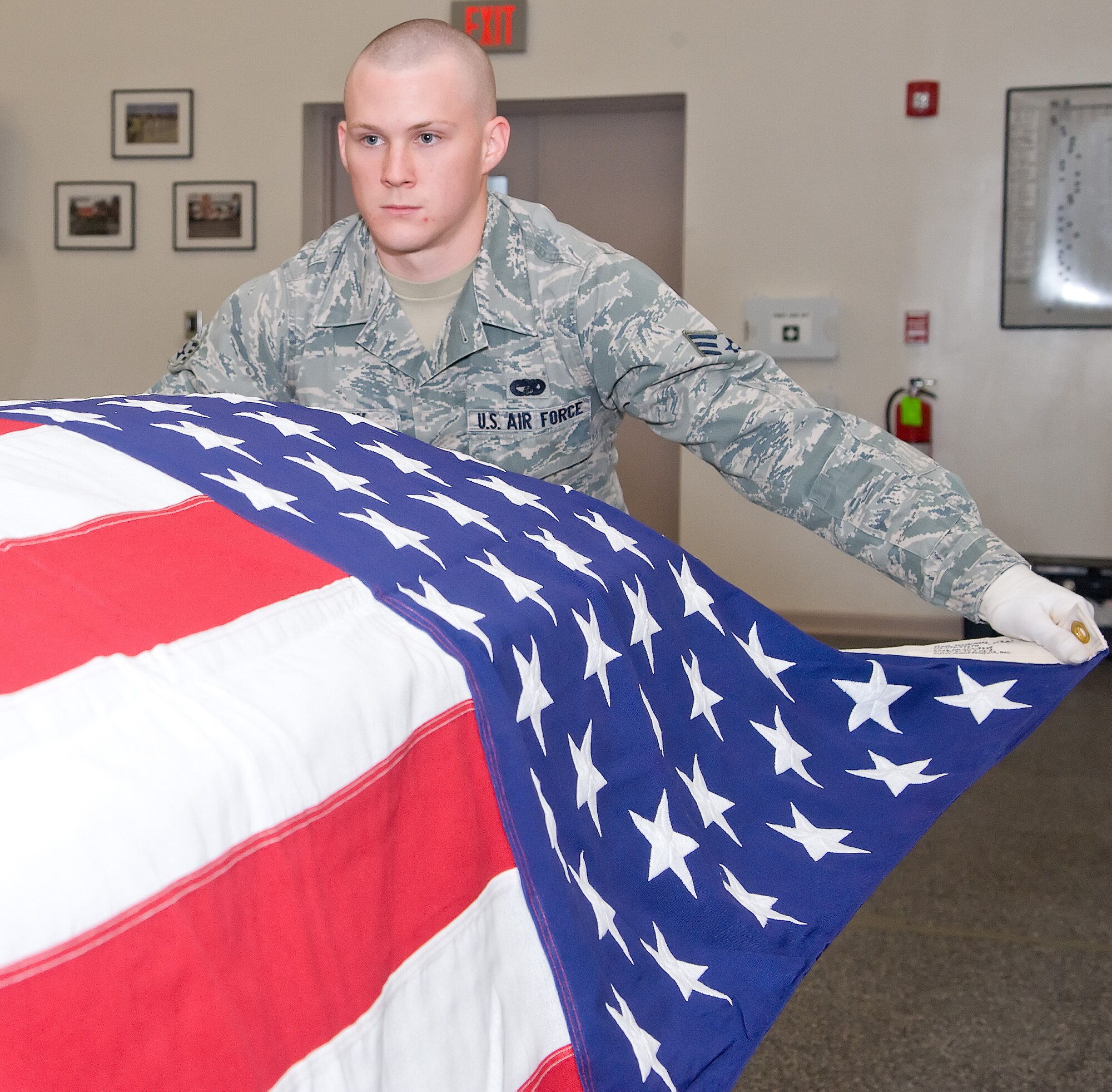 Senior Airman Joshua Stanley, a ceremonial guardsman, drapes the American flag over a simulated casket Oct. 20, 2011, at the Honor Guard facility at Dover Air Force Base, Del. Honor Guard members learn almost all the necessary skills to conduct drill and ceremony while in Training Flight. (U.S. Air Force photo by Adrian Rowan)  