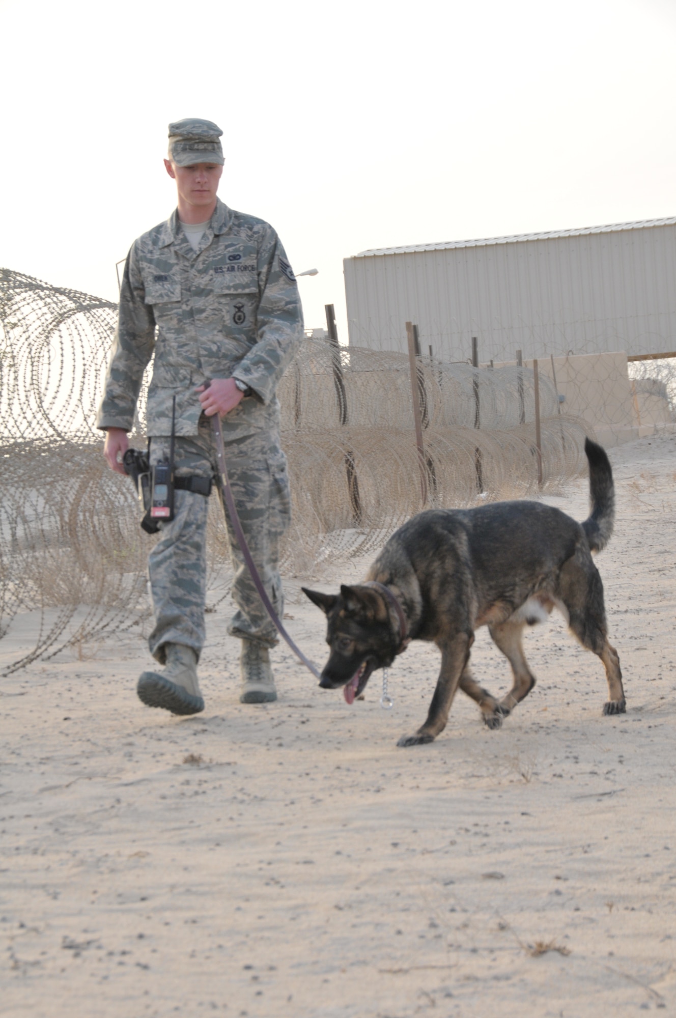 Staff Sgt. Steven Owen, 332nd Expeditionary Security Forces Squadron military working dog handler, checks the perimeter with his MWD Tex at an undisclosed location in Southwest Asia Oct. 20, 2011. Owen and Tex are deployed from Offutt Air Force Base, Neb. Owen is a native of Kansas City, Kan. (U.S. Air Force photo by 1st Lt. Rusty Ridley)