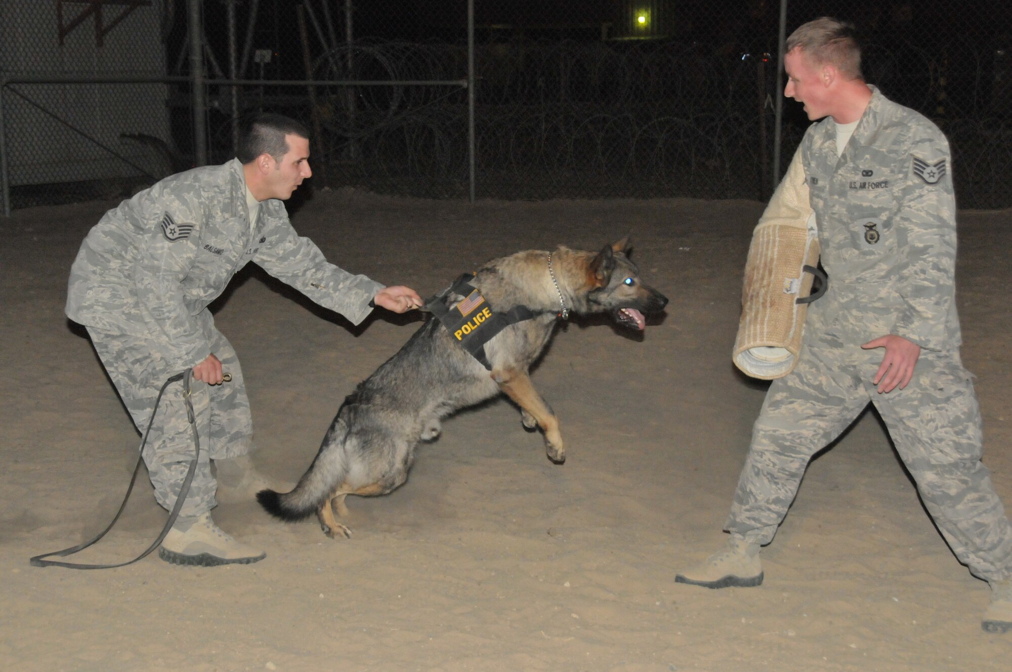 Staff Sgts. Aaron Balsamo and Steven Owen, both 332nd Expeditionary Security Forces Squadron military working dog handlers, train with MWD Errol at an undisclosed location in Southwest Asia Oct. 13, 2011. Balsamo and Owen are deployed from Offutt Air Force Base, Neb., and are natives of Pittsburgh, Penn., and Kansas City, Kan., respectively. (U.S. Air Force photo by 1st Lt. Rusty Ridley)