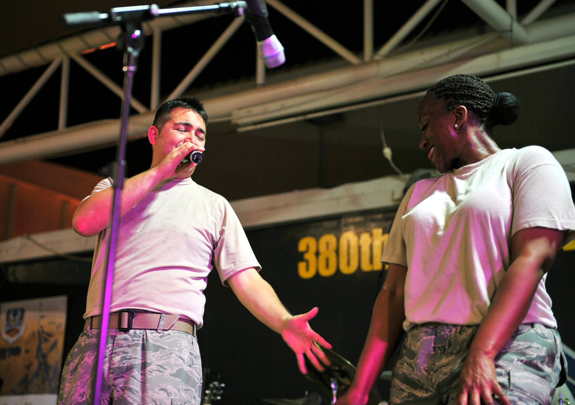Staff Sgt. Edward J. Allen and Tech. Sgt. Amber Grimes, the vocalists for Top Cover, perform for a crowd of more than 400 deployed men and women at the 380th Air Expeditionary Wing Oct. 19, 2011. Top Cover is the U.S. Air Forces Central Command band, and they visited the base to raise the morale of the deployed Airmen, Soldiers and Sailors at the wing. The band played several small acoustic sets at back shops around the wing and a pair of full-length powered shows during their visit to the deployed wing. (U.S. Air Force photo/Tech. Sgt. Patrick Mitchell)