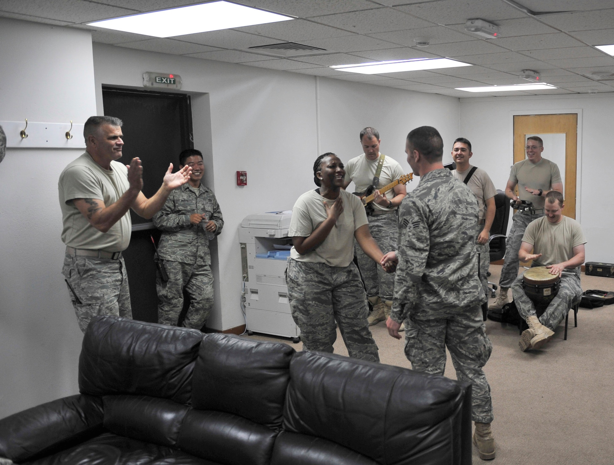 Tech. Sgt. Amber Grimes, the lead vocalist for Top Cover, the U.S. Air Forces Central Command band, serenades an Airman from the 380th Expeditionary Civil Engineer Squadron during a performance at Fire Station 1 Oct. 19, 2011, at the 380th Air Expeditionary Wing in Southwest Asia. The band played several small acoustic sets at back shops around the wing and a pair of full-length powered shows during their visit to the deployed wing. (U.S. Air Force photo/Tech. Sgt. Patrick Mitchell)