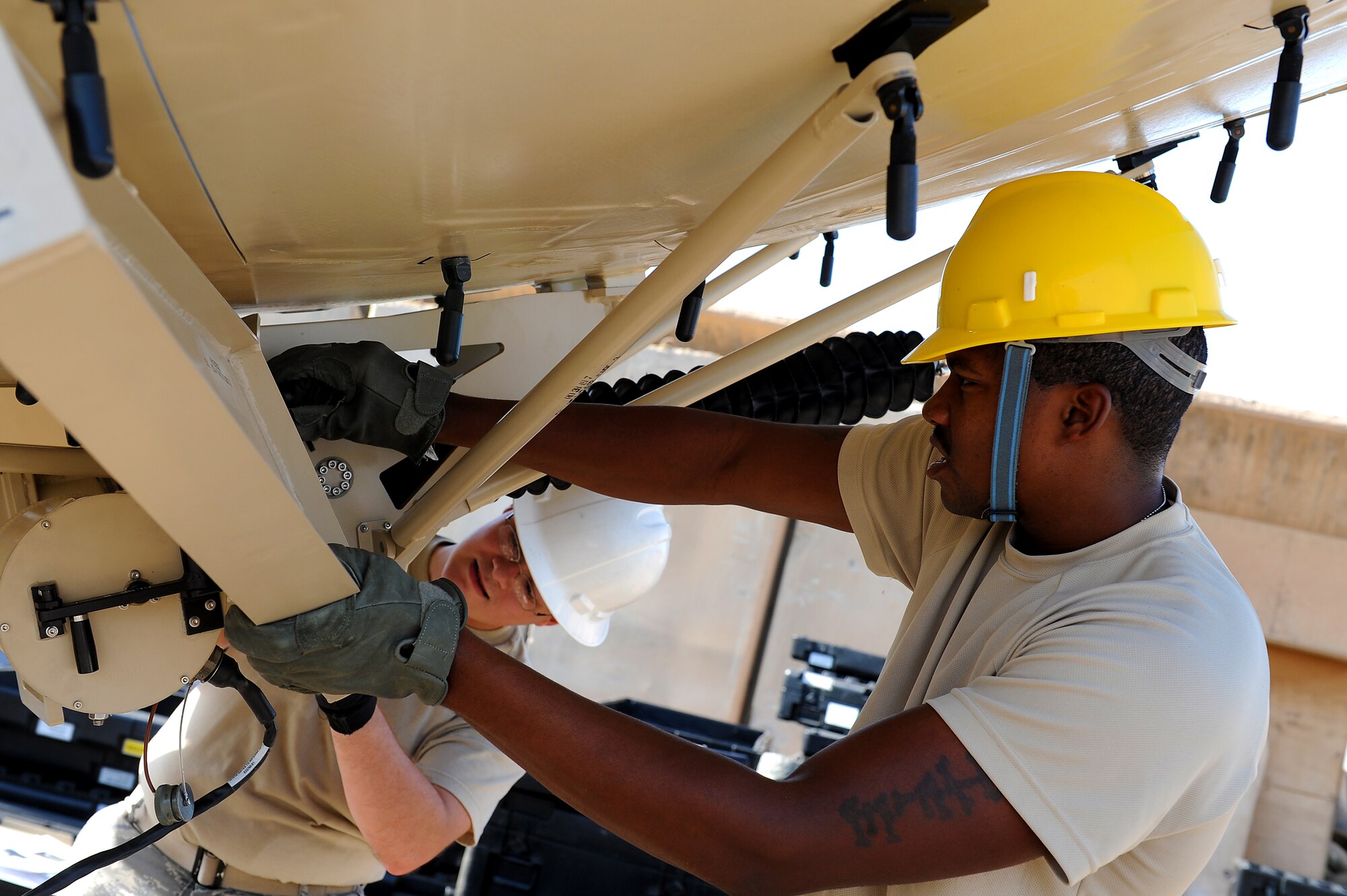 Senior Airman Drew Wilshire and Airman 1st Class Chris Howard, 5th Combat Communications Group, Robins Air Force Base, Ga., assemble a tactical satellite communications called a ground multiband terminal, or GMT, at Sather Air Base, Iraq, Oct. 7, 2011. The tactical communications network is being set up for Airmen on the ground as the U.S. military continues preparation for the scheduled withdrawal. Howard is from Wichita, Kan., and Wilshire calls Erie, Pa., home. (U.S. Air Force photo/Staff Sgt. Mike Meares)