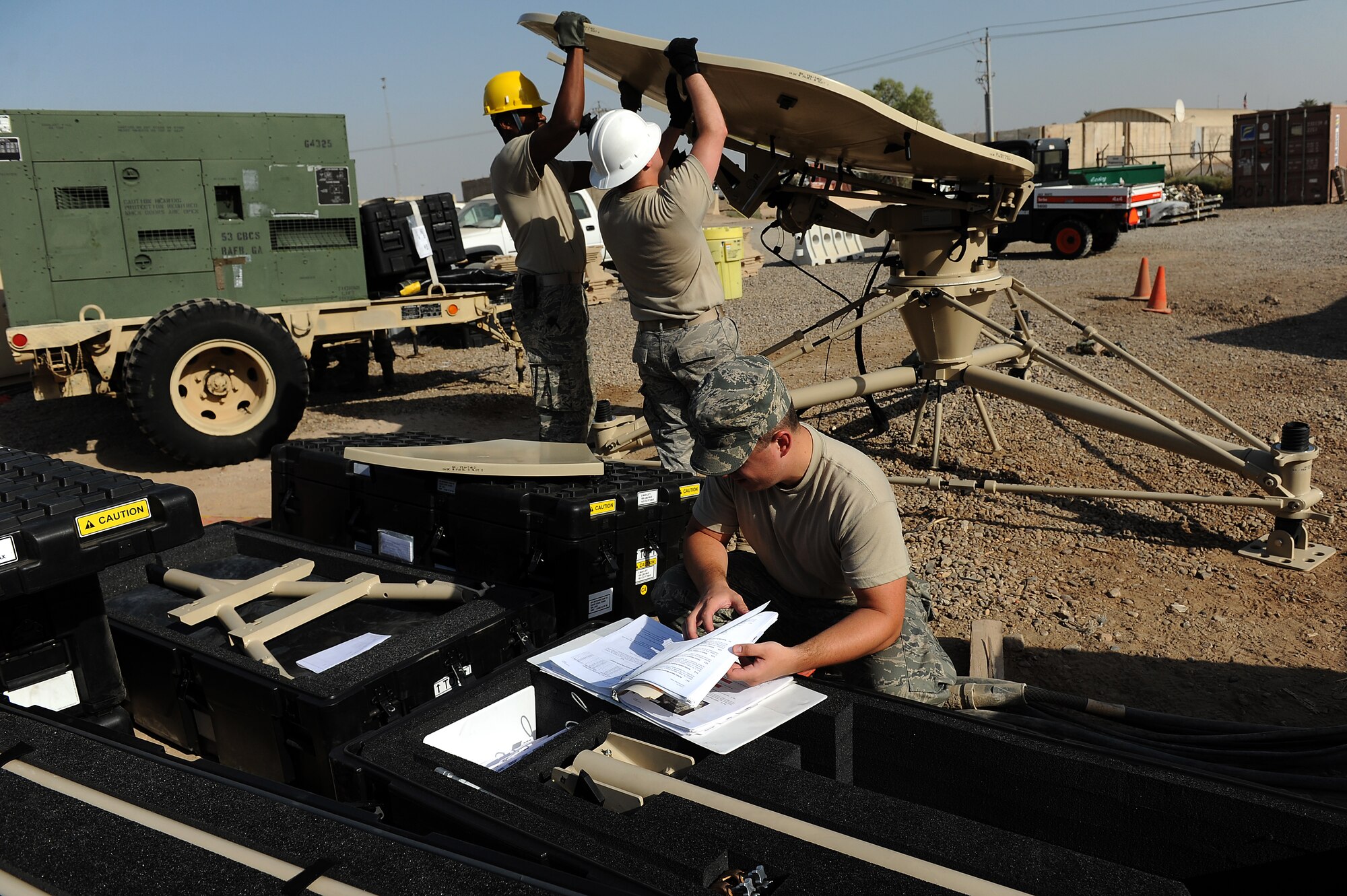 Senior Airmen Jarod Bierman and Drew Wilshire and Airman 1st Class Chris Howard, 5th Combat Communications Group, Robins Air Force Base, Ga., assemble a tactical satellite communications called a ground multiband terminal, or GMT, at Sather Air Base, Iraq, Oct. 7, 2011. The tactical communications network is being set up for Airmen on the ground as the U.S. military continues preparation for the scheduled withdrawal. (U.S. Air Force photo/Staff Sgt. Mike Meares)