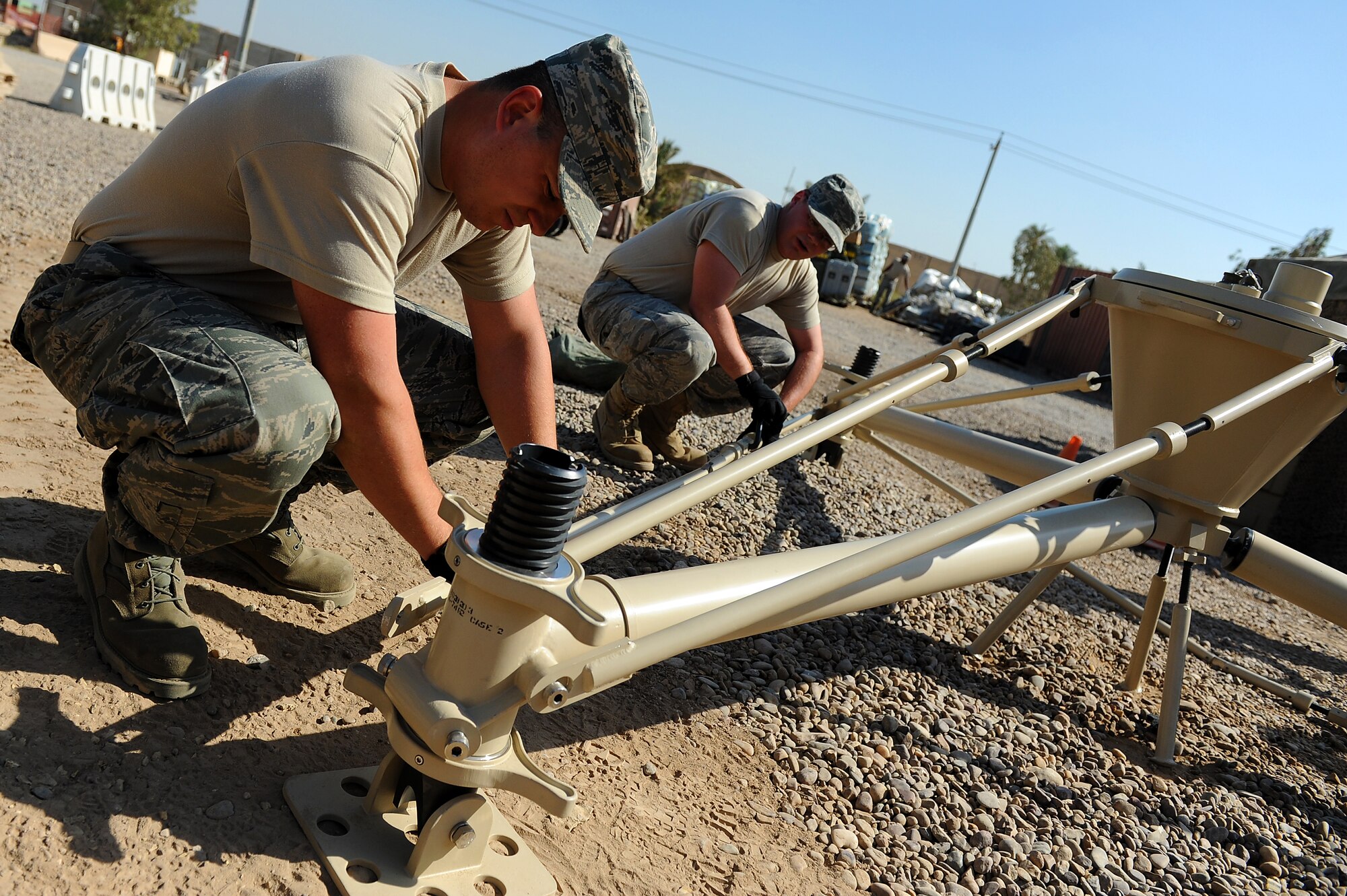 Senior Airmen Jarod Bierman and Drew Wilshire, 5th Combat Communications Group, Robins Air Force Base, Ga., assembles pieces of a tactical satellite communications called a ground multiband terminal, or GMT, at Sather Air Base, Iraq, Oct. 7, 2011. The tactical communications network is being set up for Airmen on the ground as the U.S. military continues preparation for the scheduled withdrawal. (U.S. Air Force photo/Staff Sgt. Mike Meares)