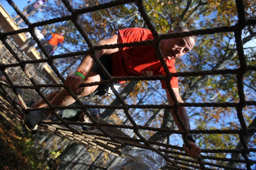 Capt. Nick Schroback, Company B 3rd Platoon commander, traverses a rope net during Tough Mudder at Wintergreen, Va., Oct. 22, 2011. Tough Mudder, a 10-mile race through rough terrain and 27 obstacles, was the 12th of 17 events that compose Marine Barracks Washington's 2011 Commander's Cup.
