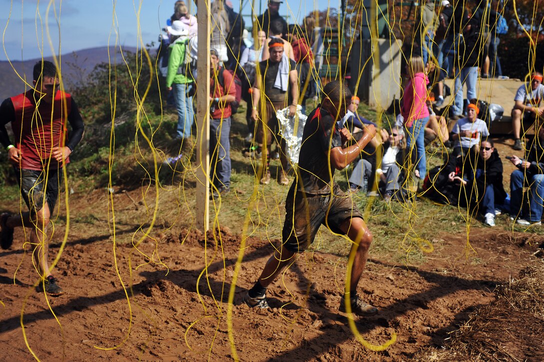 Lance Cpl. Logan Sierra, left, and Lance Cpl. Malcolm Elzie, Company A ceremonial marchers, run through hundreds of dangling, exposed live wires during Tough Mudder at Wintergreen, Va., Oct. 22, 2011. Tough Mudder, a 10-mile race through rough terrain and 27 obstacles, was the 12th of 17 events that compose Marine Barracks Washington's 2011 Commander's Cup.