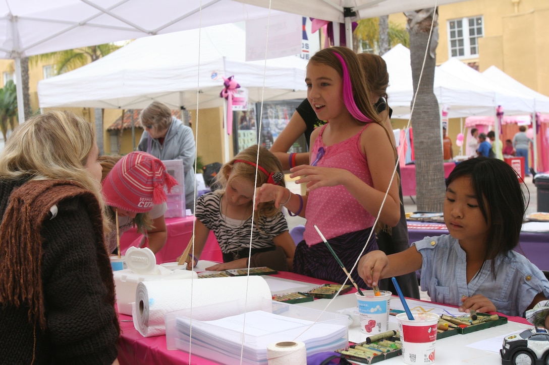 Children create art projects of people they knew affected by domestic violence and breast cancer Oct. 22 at the art therapy booth on Marine Corps Recruit Depot San Diego during Make a Difference Day 2011 Walk and Wellness Expo. Marine Corps Community Services hosted the day to raise awareness on the two issues. The children's artwork was put into a collage, giving the children a way to contribute.