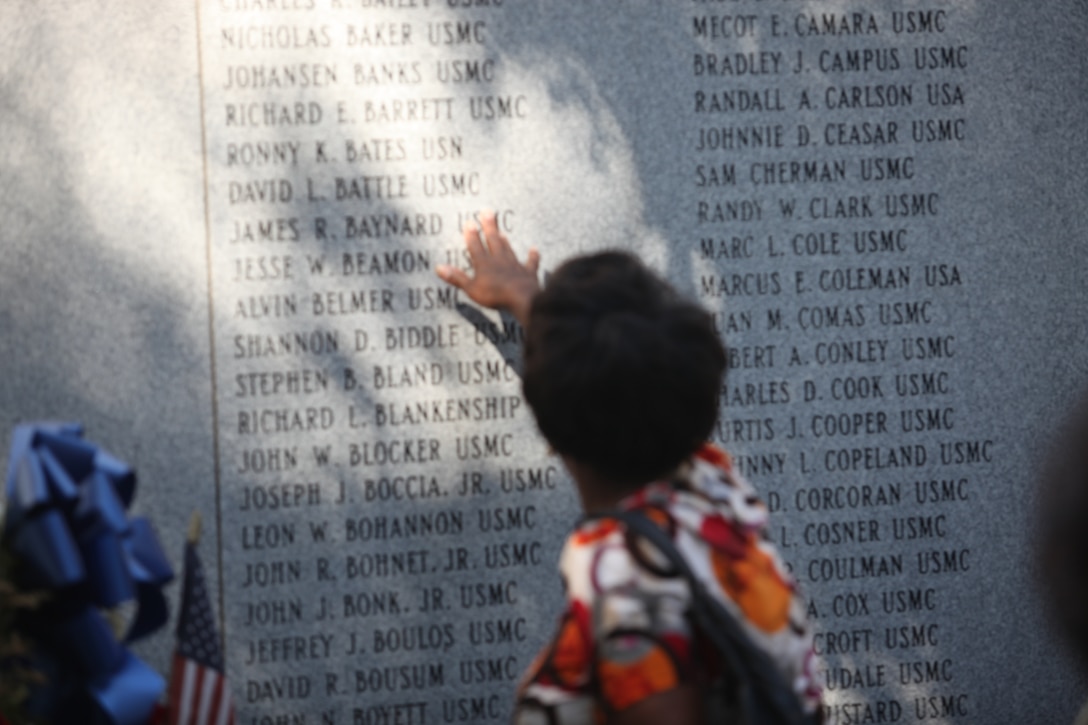 A Beirut Memorial Observance Ceremony attendee finds a name of a Marine, who lost his life in the Beirut bombing at Marine barracks, in Beirut, Lebanon at the Beirut Memorial wall at the Lejeune Memorial Gardens in Jacksonville, N.C., Oct. 23. The bombings killed 241 Marines, sailors and soldiers on Oct. 23, 1983.