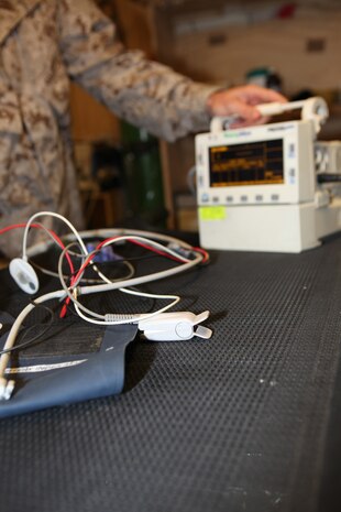 Lt. Cmdr. John Steely, a medical officer with the Delaram Shock Trauma Platoon, Bravo Surgical Company, Marine Air-Ground Task Force Support Battalion 11.2, 2nd Marine Logistics Group (Forward), demonstrates how to turn on various pieces of medical equipment at the STP facility aboard Forward Operating Base Delaram II, Afghanistan, Oct. 23.  Every patient who comes in receives a medical screening, complete with vitals and medical history.  (U.S. Marine Corps photo by Cpl. Katherine M. Solano)