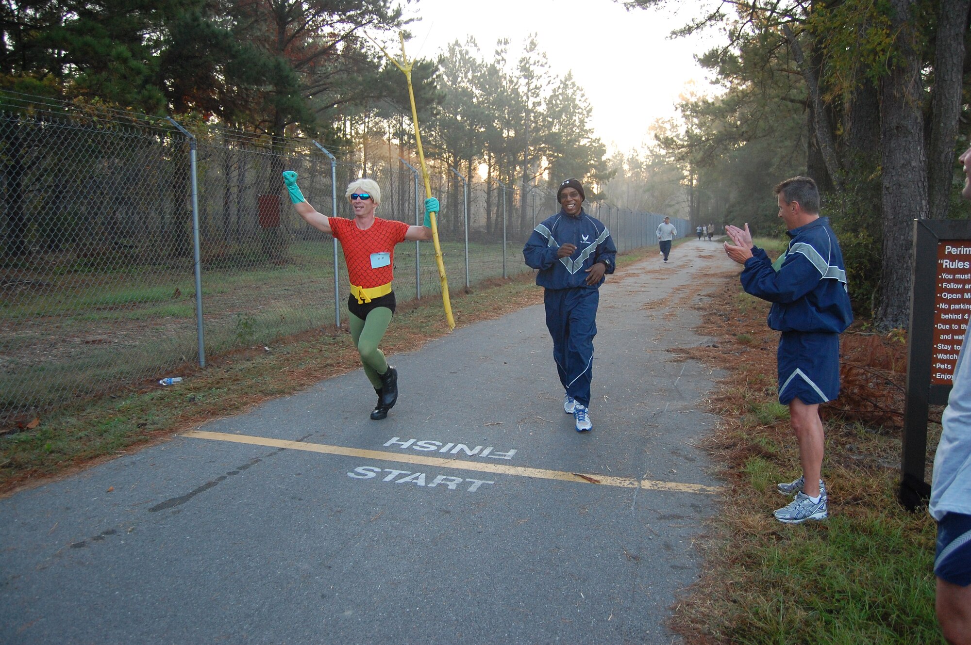Tech. Sgt. Ian Gardner crosses the finish line as the Justice League's Aqua Man during the wing's semi-annual Warrior Run. The two-mile costume run was in honor of the wing's 25th anniversary celebration. Gardner won for best costume. (USAF photo by SSgt. Mark Thompson, 916ARW/PA)