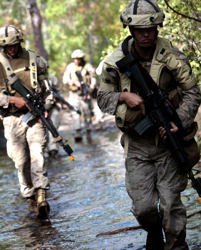 Marines with 8th Communication Battalion, 2nd Marine Division, patrol alongside a road, while donning the Integrated Target Environment Scenario Tool or ITEST, during the expeditionary communication training held aboard Marine Corps Base Camp Lejeune, N.C., Oct. 24. During the Marines’ training, the ITEST vest recorded information such as where the Marines were hit by an enemy’s laser, the Marines GPS position and their number of blank rounds fired.
