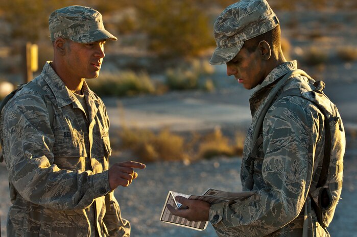 U.S. Air Force Staff Sgt. Jason Bell, 60th Security Forces Squadron security forces craftsman from Travis Air Force Base, Calif., and Airman 1st Class Andrew Timler, 509th Security Forces Squadron security forces apprentice from Whiteman Air Force Base, Mo., review plans for a training mission for the Ranger Assessment and Selection Course Oct. 21, 2011, at the Nevada Test and Training Range. Airmen must attend the RAS course before going to the U.S. Army Ranger School, which is designed to train armed forces personnel to conduct combat operations within enemy lines. (U.S. Air Force photo by Airman 1st Class George Goslin/Released)