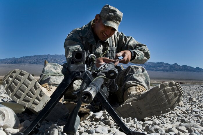 U.S. Air Force Staff Sgt. Gene Aguirre, 6th Special Operations Squadron security forces craftsman from Hurlburt Field Air Force Base, Fla., takes apart a M-240B machine gun and cleans it before a training mission during the Ranger Assessment and Selection Course Oct. 21, 2011, at the Nevada Test and Training Range. Airmen must attend the RAS course before going to the U.S. Army Ranger School, which is designed to train armed forces personnel to conduct combat operations within enemy lines. (U.S. Air Force photo by Airman 1st Class Daniel Hughes/Released)