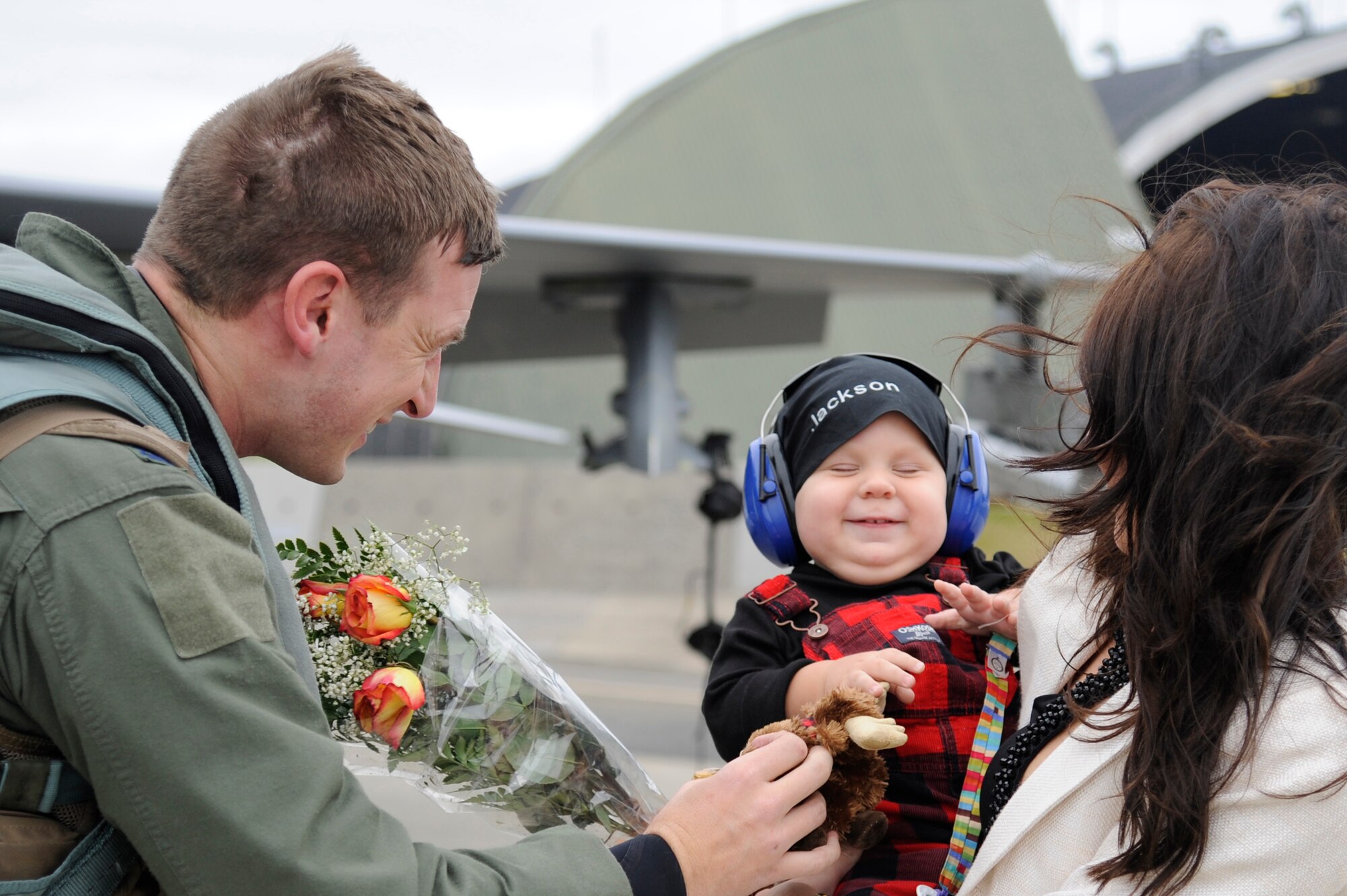 MISAWA AIR BASE, Japan - U.S. Air Force Capt. Scott Kotowski, left, 13th Fighter Squadron, reunites with his wife Natalee and son Jackson here Oct. 24. Several F-16 Fighting Falcons, with the 13 FS, returned home after an approximate one month long stay at Eielson Air Force Base, Alaska, in support of Operation Noble Eagle, Red Flag-Alaska and Distant Frontier exercise. (U.S. Air Force photo/Tech. Sgt. Marie Brown)