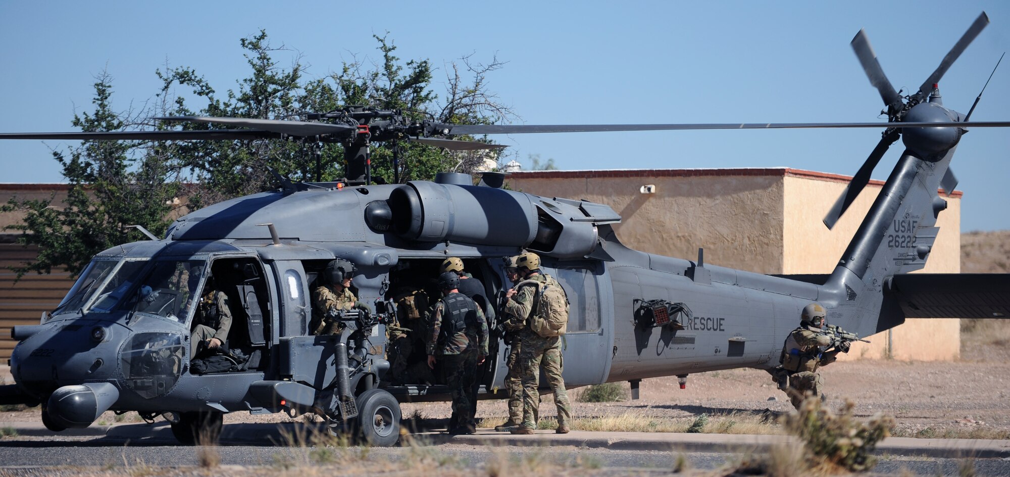 PLAYAS, N.M. – A lone pararescueman provides cover as his teammates load two rescued hostages into a helicopter during a training scenario at Playas Training and Research Facility in New Mexico Oct. 20. Scenarios such as evasion in a mountainous environment, hostage rescues and mass casualty scenarios, all of which could be actual operations in our deployed environments, are run out of the facility. (U.S. Air Force photo/Airman 1st Class Michael Washburn)