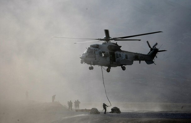 U.S. Air Force Maj. Scott Adams, 0167th Pyrenees helicopter pilot, hold his EC-725 Caracal in a hover as French pararescuemen attach equipment to harness lines for loading during a deployment to Afghanistan. Adams, who is part of an exchange pilot program, was deployed with a French unit under French command. The goal of the exchange pilot program is to allow countries to share knowledge and tactics. (Courtesy photo)
