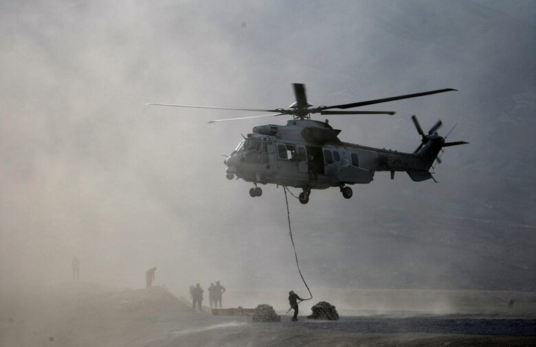 AFGHANISTAN -- Maj. Scott Adams, 0167th Pyrenees helicopter pilot, hold his EC-725 Caracal in a hover as French pararescuemen attach equipment to harness lines for loading during a deployment to Afghanistan. Major Adams, who is part of an exchange pilot program, was deployed with a French unit under French command. The goal of the exchange pilot program is to allow countries to share knowledge and tactics. (Courtesy Photo) 