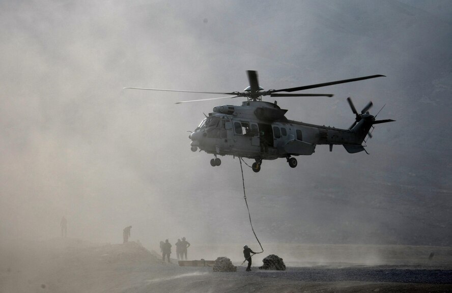 U.S. Air Force Maj. Scott Adams, 0167th Pyrenees helicopter pilot, hold his EC-725 Caracal in a hover as French pararescuemen attach equipment to harness lines for loading during a deployment to Afghanistan. Adams, who is part of an exchange pilot program, was deployed with a French unit under French command. The goal of the exchange pilot program is to allow countries to share knowledge and tactics. (Courtesy photo)