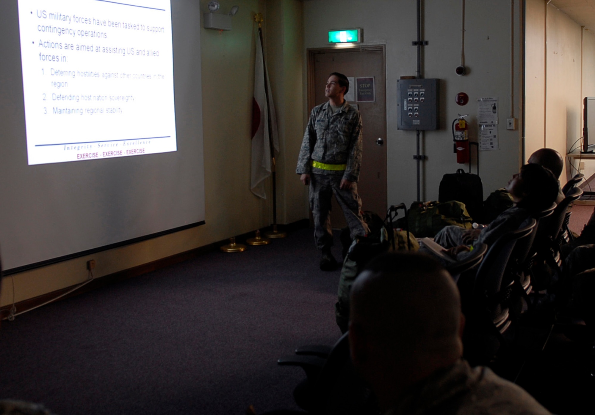 Senior Airman Cristofer Mercado, 18th Logistics Readiness Squadron passenger travel clerk, gives a group of simulated deployers an outbound briefing during local operational readiness exercise Beverly High 12-1 at Kadena Air Base, Japan, Oct. 25. Each briefing goes over the basics of dos and don?ts while in a deployed environment. (U.S. Air Force photo/ Airman 1st Class Tara A. Williamson/ released)