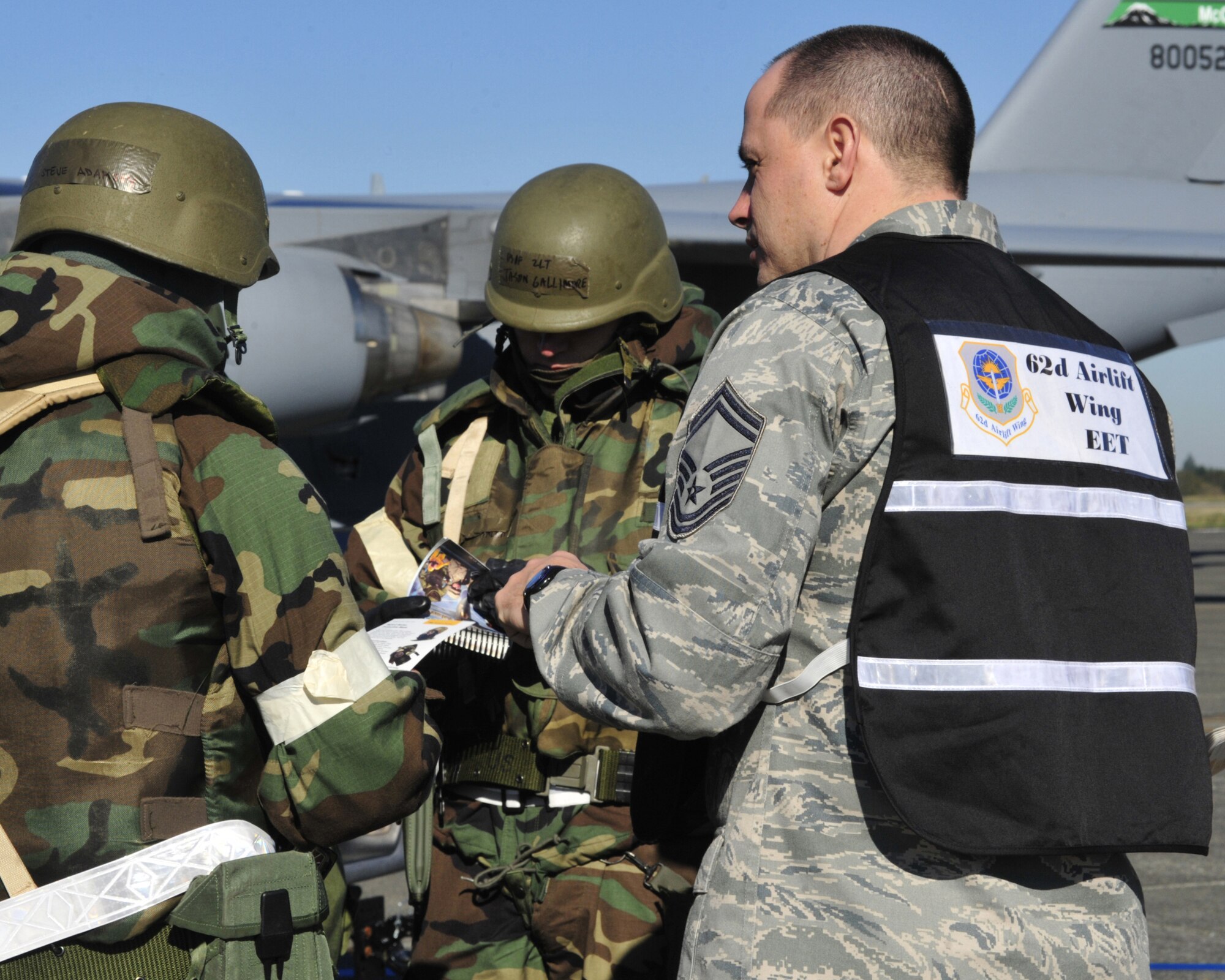 Airman 1st Class Steve Adamski and 2nd Lt. Jason Gallimore, 62nd Aircraft Maintenance Squadron, refer to their Airman's Manual to provide an answer for an exercise evaluation team member during a mobility exercise Oct. 18, 2011, at Joint Base Lewis-McChord, Wash. The 62nd Airlift Wing and 627th Air Base Group conducted the exercise in preparation for an operational readiness inspection in 2012. (U.S. Air Force photo/Staff Sgt. Frances Kriss)