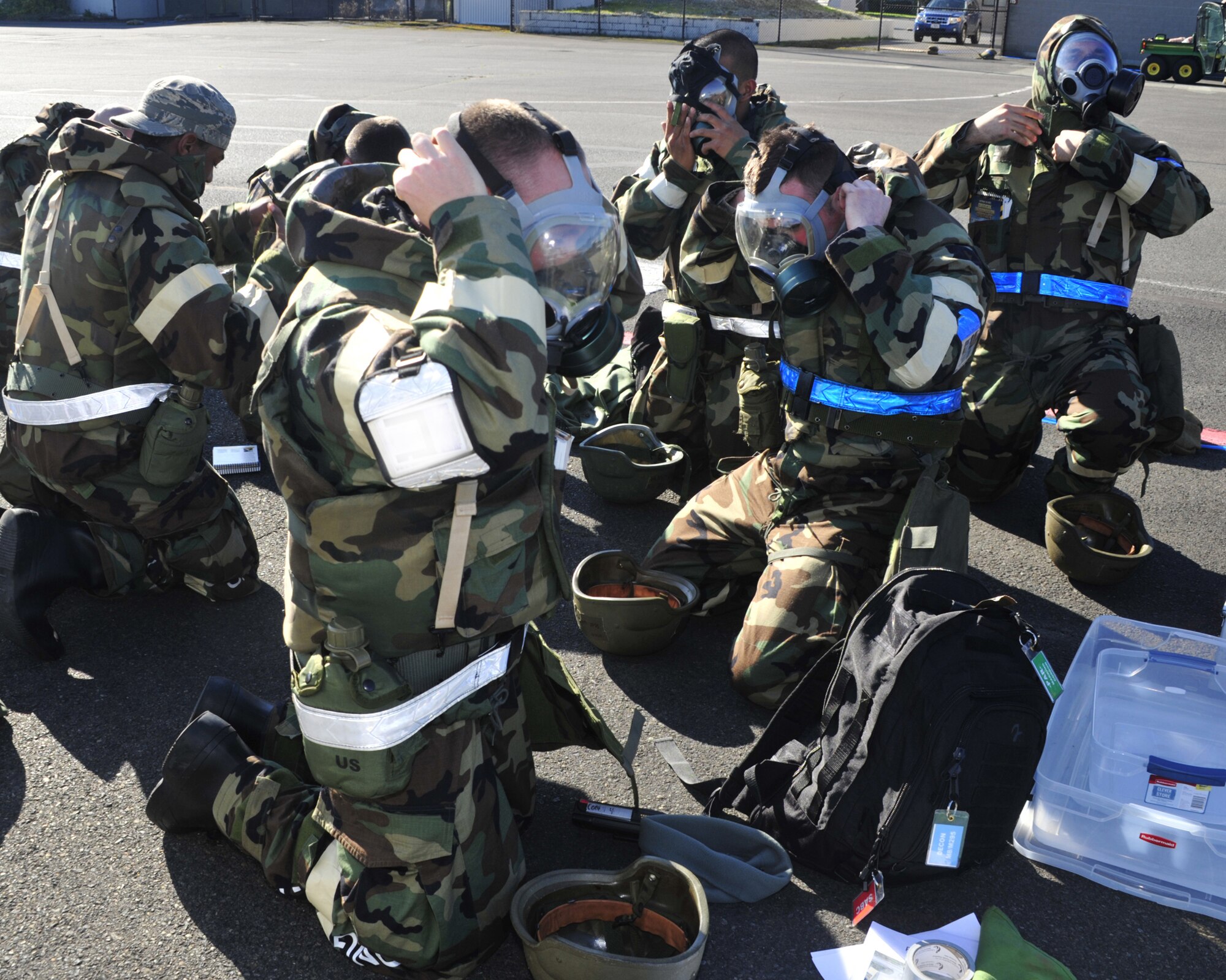 Airmen immediately don their gas masks and other mission oriented protective posture gear after notification of a simulated ground attack during a mobility exercise Oct. 18, 2011, at Joint Base Lewis-McChord, Wash.  The purpose of the MOBEX is to evaluate the 62nd Airlift Wing and 627th Air Base Group's ability to meet wartime and contingency tasks of employing forces, sustaining forces and maintaining the ability to survive and operate in a deployed location. (U.S. Air Force illustration/Staff Sgt. Frances Kriss)