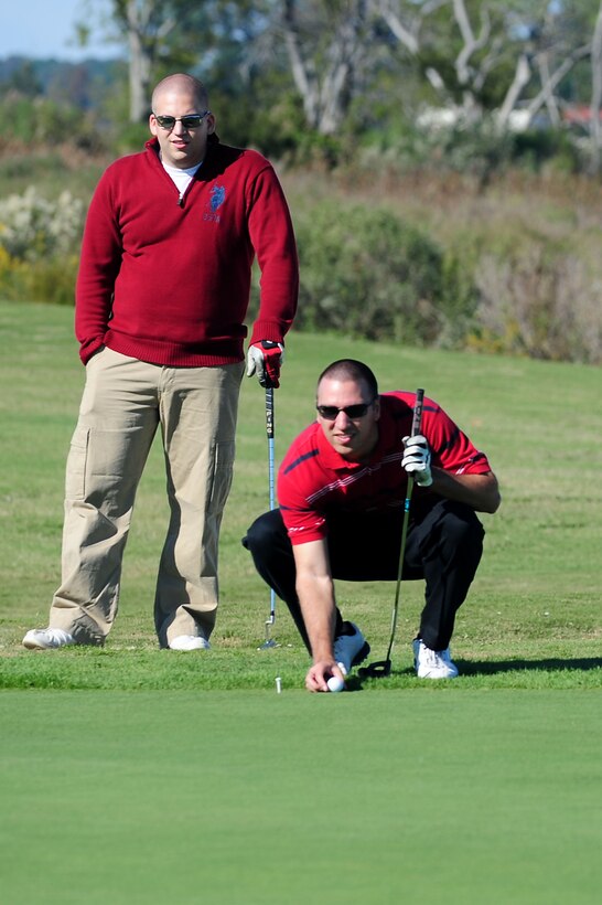 U.S. Air Force Senior Airman Tim Lowe, 633rd Air Base Wing Communications Squadron network architecture technician, and Staff Sgt. Richard Riddle, 633rd ABW Communications Squadron cyber transport supervisor, line up a shot during the second Langley Chief's Group "Chief Mik" Golf Tournament at Langley Air Force Base, Va., Oct. 21, 2011. The tournament is held in honor of the late Chief Master Sgt. Denise Mikolajczyk, who was stationed at Langley AFB, when she died Jan. 11, 2009 as a result of a benign tumor that blocked her mitral valve. (U.S. Air Force photo by Airman 1st Class Kayla Newman/Released)