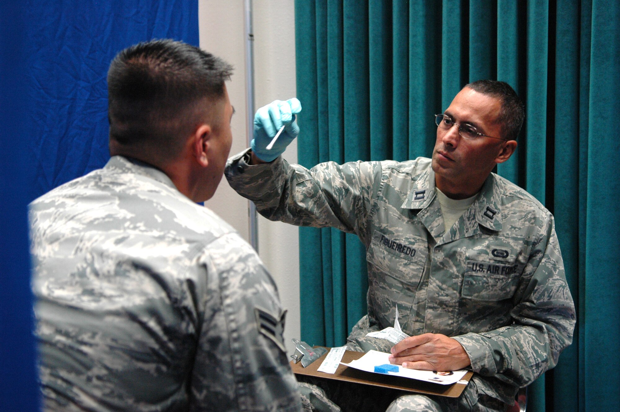 Capt. Richard Figueiredo, 552nd Operations Support Squadron, takes a cheek swab from an Airman during a Bone Marrow Donor recruitment drive in Bldg. 283 Oct. 14. The drive collects DNA from potential donors to match them with a patient. Some donors are never matched, while some who are matched may wait years before getting a call to donate. During the drive, more than 400 people registered with the Department of Defense Bone Marrow Center. Captain Figueiredo himself is a recipient of a bone marrow transplant after being diagnosed with Acute Myloid Leukemia in 2006. His brother was the donor. “It was a life changing experience that reinforced my commitment to help the fight against cancer,” the captain said. (Air Force photo by Micah Garbarino)
