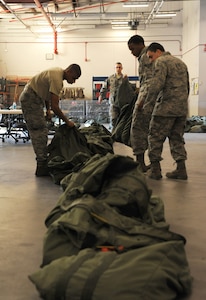 Airmen place Chemical-bags in the correct order at Joint Base Charleston - Air Base, Oct. 20, in preparation for the JB Charleston Operational Readiness Exercise. A C-bag is issued to deploying Airmen if there is a chemical-biological threat in the deployment area and contains two complete ground crew ensembles, M8/M9 paper and decontamination kits. (U.S. Air Force photo/Airmen 1st Class Ashlee Galloway)