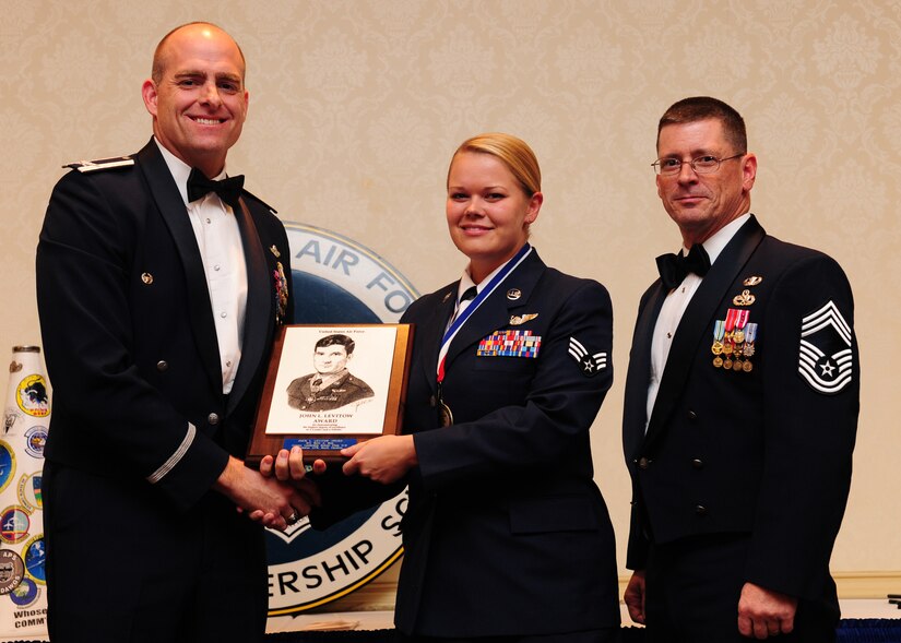 Col. Darren James and Chief Master Sgt. Jimmy Lewis present the John L. Levitow Award to Senior Airman Kelli Stee during the Airman Leadership School Class graduation ceremony at Joint Base Charleston - Air Base Oct. 20. The John Levitow award is presented to the Airman that displays the best overall performance evaluation, peer to staff rating and academic ranking while attending ALS, a six-week course designed to develop Airman into effective leaders and supervisors.James is the 437th Airlift Wing vice commander, Lewis is the 437th Maintenance Group superintendent and Stee is a loadmaster journeyman with the 17th Airlift Squadron. (U.S. Air Force photo/Staff Sgt. Katie Gieratz) 