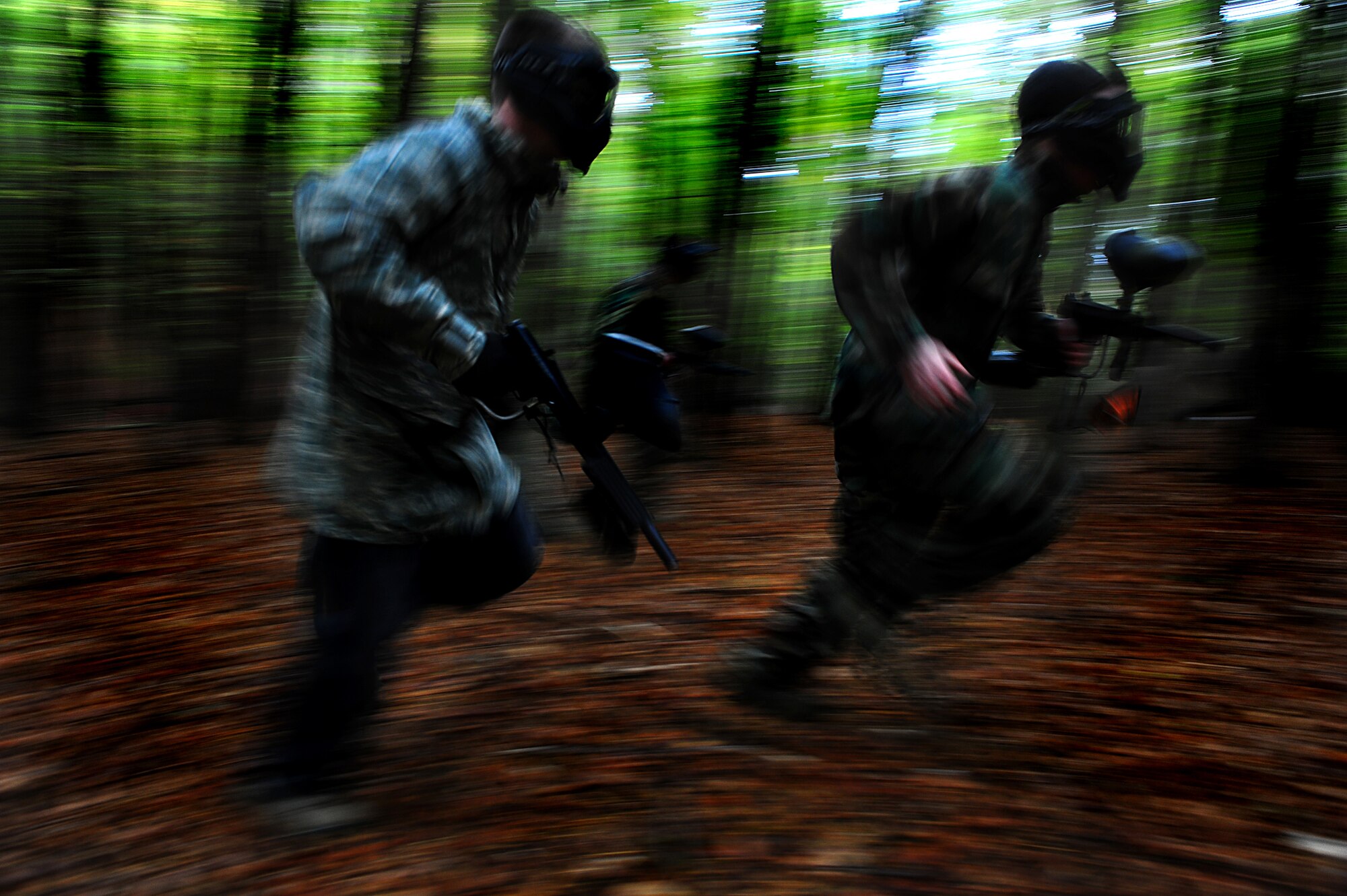 Air Force Airmen from the 786th Civil Engineer Squadron run for cover while playing capture the flag during Oktober Fun Fest at the Rod and Gun Club, Vogelweh Air Station, Germany, Oct. 21, 2011. The event was organized for a day of fun, food, and friendly competition and helped enhance camaraderie and raise morale. (U.S. Air Force photo by Airman 1st Class Brea Miller)