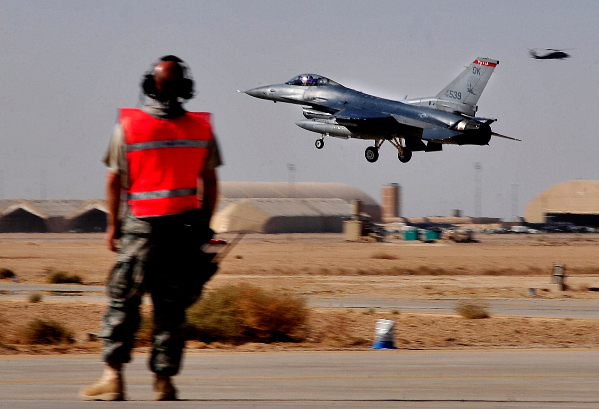 A crew chief from the 125th Expeditionary Fighter Squadron watches an F-16 Fighting Falcon from his squadron arrive in Iraq Oct. 1, 2011. The squadron deployed in support of Operation New Dawn and will provide close air support for more than 40,000 troops leaving Iraq by the end of the year. The 125th EFS is comprised of F-16s, pilots, maintenance specialists and support personnel from the Oklahoma Air National Guard’s 138th Fighter Wing in Tulsa, Okla. The squadron also includes members from the Ohio Air National Guard’s 180th Fighter Wing in Toledo, Ohio, and the Arizona Air National Guard’s 162nd Fighter Wing in Tucson, Ariz. (U.S. Air Force photo/Master Sgt. Cecilio Ricardo)