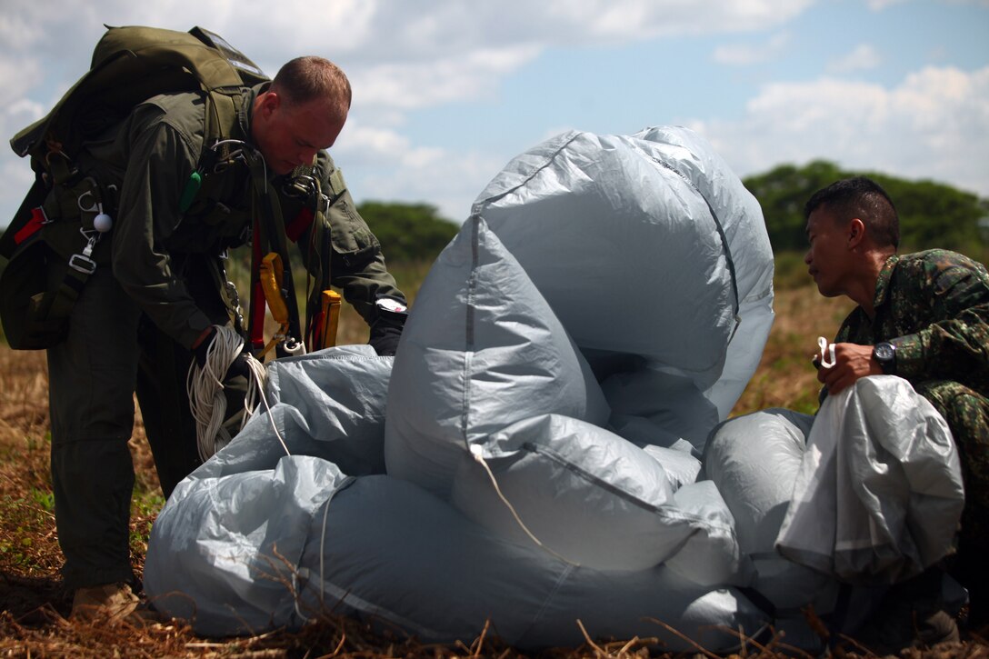 A Marine with Force Reconnaissance Platoon, 31st Marine Expeditionary Unit, packs up his parachute with the help of a Philippine Marine, Oct. 25. The Marines were conducting bilateral parachute training with their Philippine counterparts during the Amphibious Landing Exercise. The 31st MEU is operating in support of the 3rd Marine Expeditionary Brigade for the exercise, is the only continuously forward-deployed MEU and remains the United States’ force in readiness in the Asia-Pacific region.