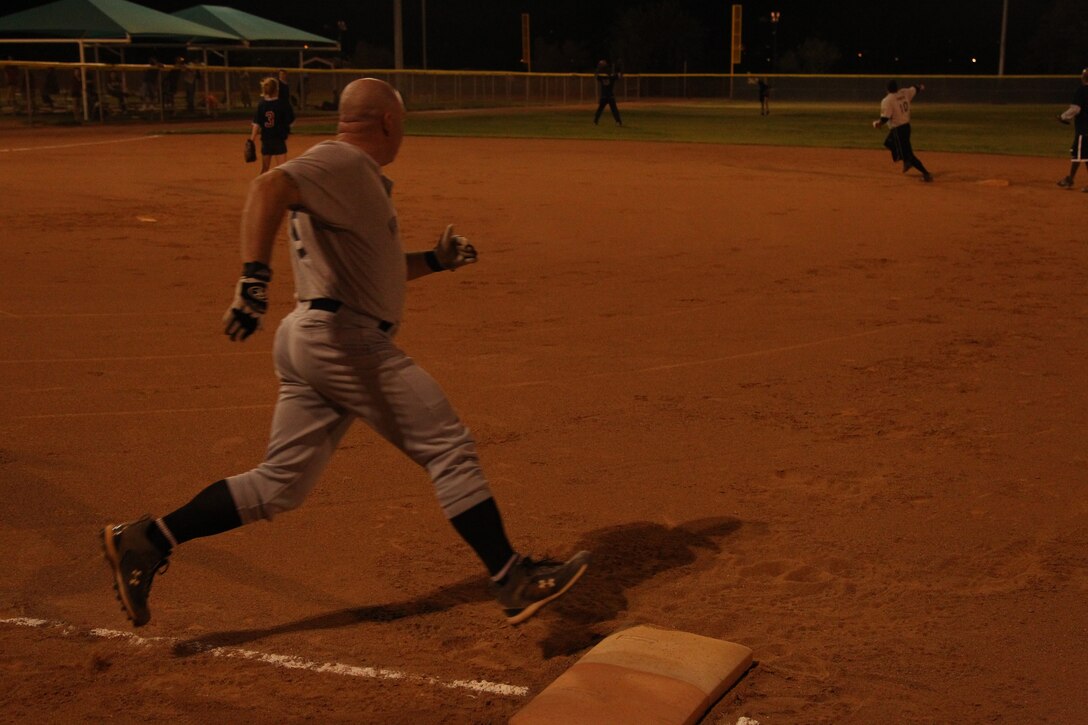 MCTOG Spartans coach and pitcher Joe Stager rounds first base during a co-ed softball league game at Felix Field Oct. 25, 2011. The MCTOG Spartans defeated the Ballz & Dollz 18-12.